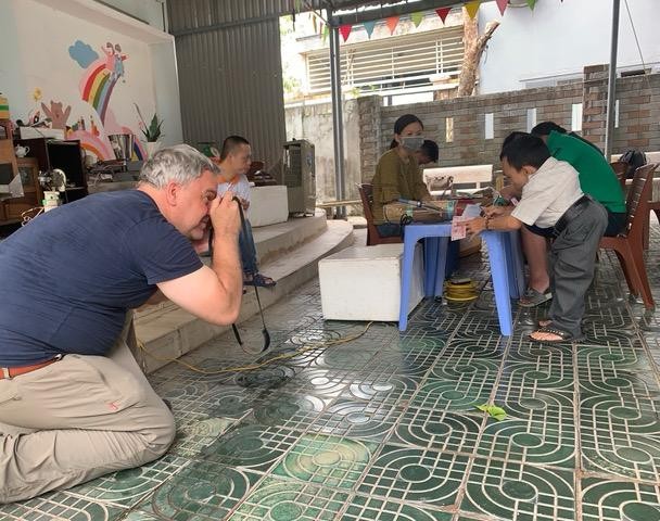 Im Bild fotografiert Roland Schmid Agent-Orange-Opfer. Es sind kleinwüchsige Vietnamesen. Kleinwüchsigkeit ist eine der Folgen des Gifteinsatzes im Vietnamkrieg, der vor 50 Jahren endete.
